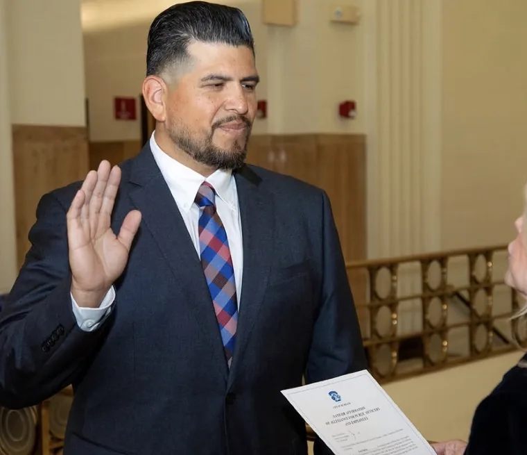 Jonathan Ontiveros raising his right hand to take an oath of affirmation of allegiance